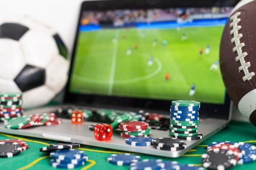 Türkiye'deki online oyun platformları için casino fişleri, zar ve futbol maçı gösteren bir dizüstü bilgisayar.